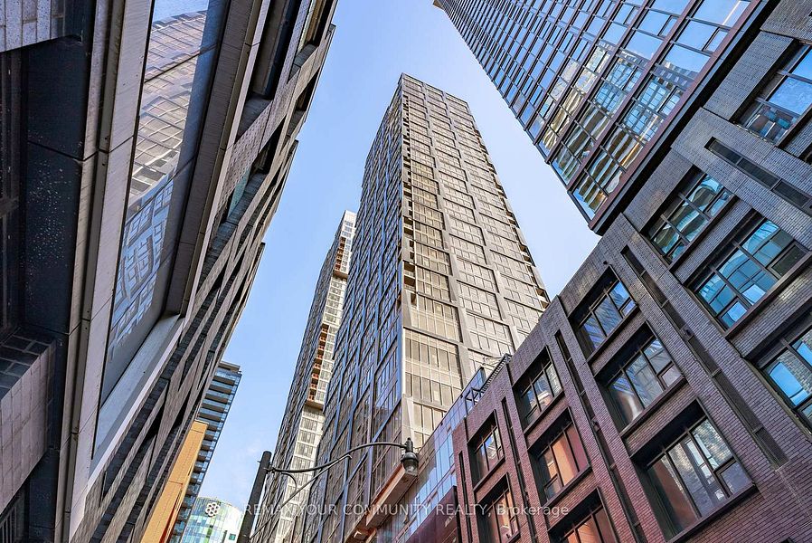 Modern high-rise condominium towers in downtown Toronto viewed from street level against a clear sky